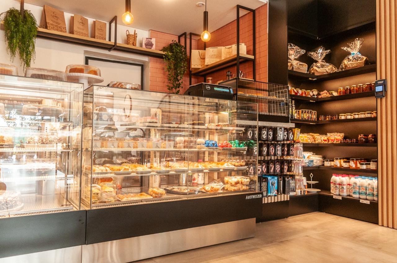 Interior da confeitaria com balcão de atendimento e vitrines